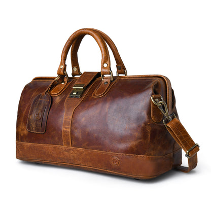 tan brown  leather duffel bag with double top handles, a detachable shoulder strap, and brass hardware, shown on a white background.