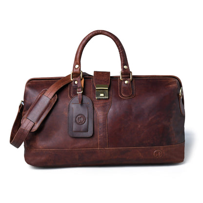 Burgundy distressed leather duffel bag with double top handles, a detachable shoulder strap, a leather luggage tag, and brass-tone hardware, shown on a white background.