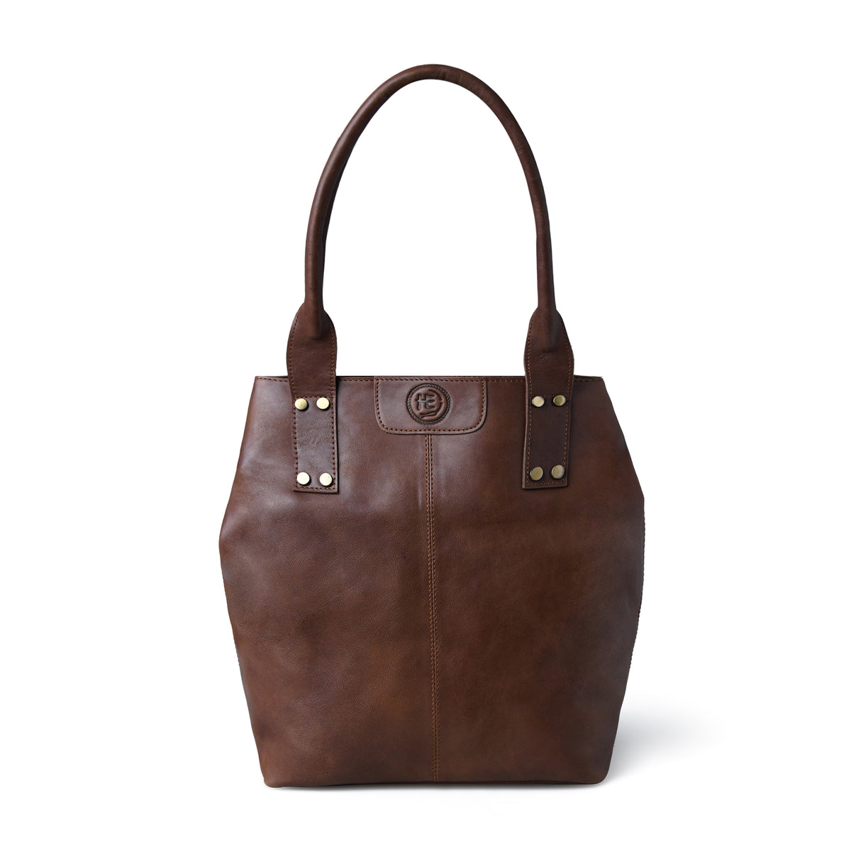 A dark brown leather tote bag with double shoulder straps, gold-tone rivets, and a circular logo medallion on the front, shown against a plain white background.