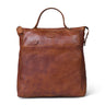 A brown leather tote bag with a top handle, front slip pocket, and a small embossed brand patch, shown on a plain white background.