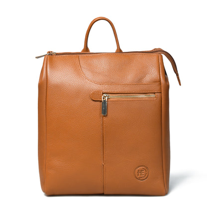 A tan Brown pebbled leather backpack with top handles, a front zippered pocket, and a circular embossed logo on the bottom right, shown on a white background.
