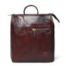 A burgundy leather backpack with a top handle, a front zippered pocket, and a circular embossed logo on the lower right, shown against a plain white background.