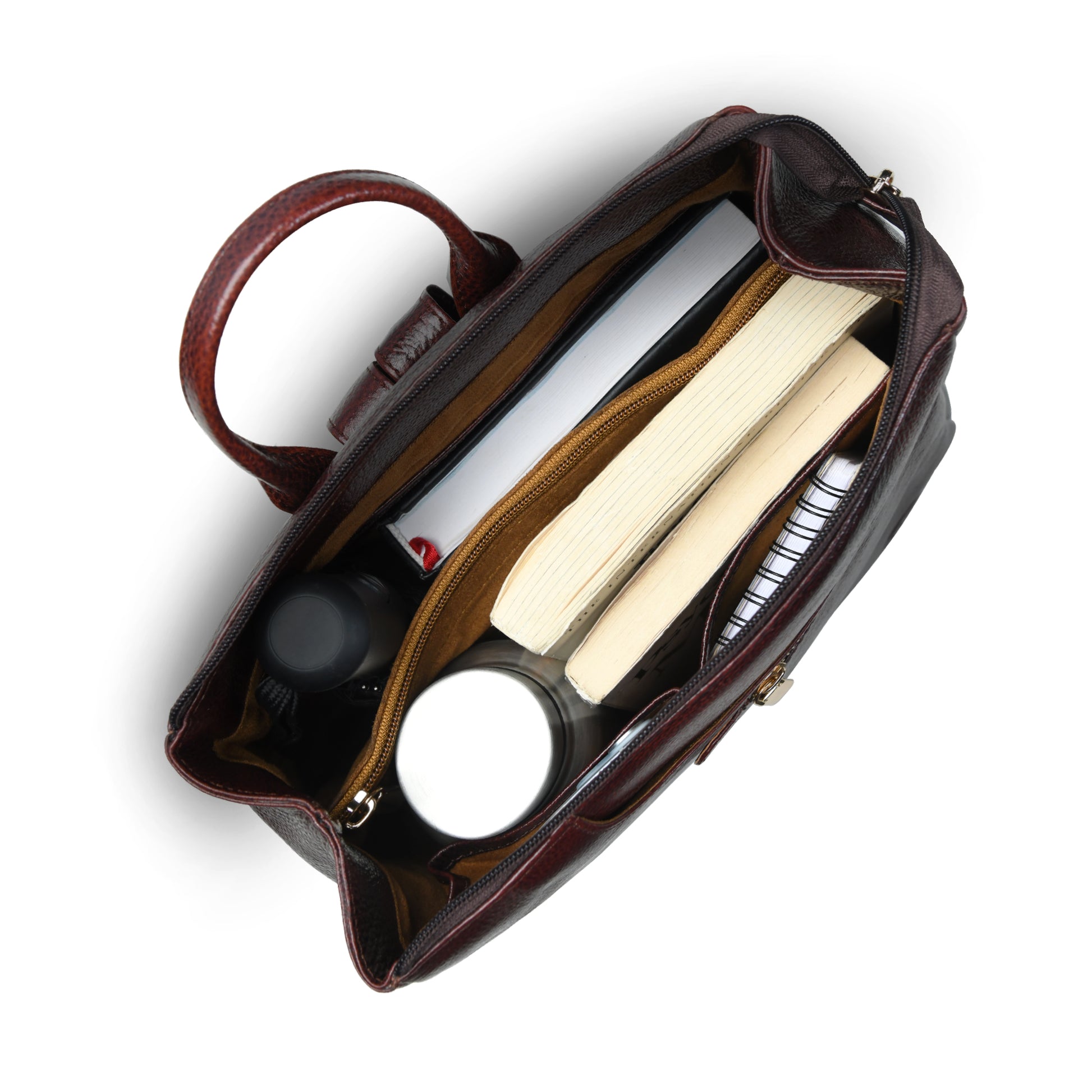 burgundy leather handbag shown from a top-down angle, open to reveal its interior compartments filled with books, a notebook, and small accessories, on a white background.